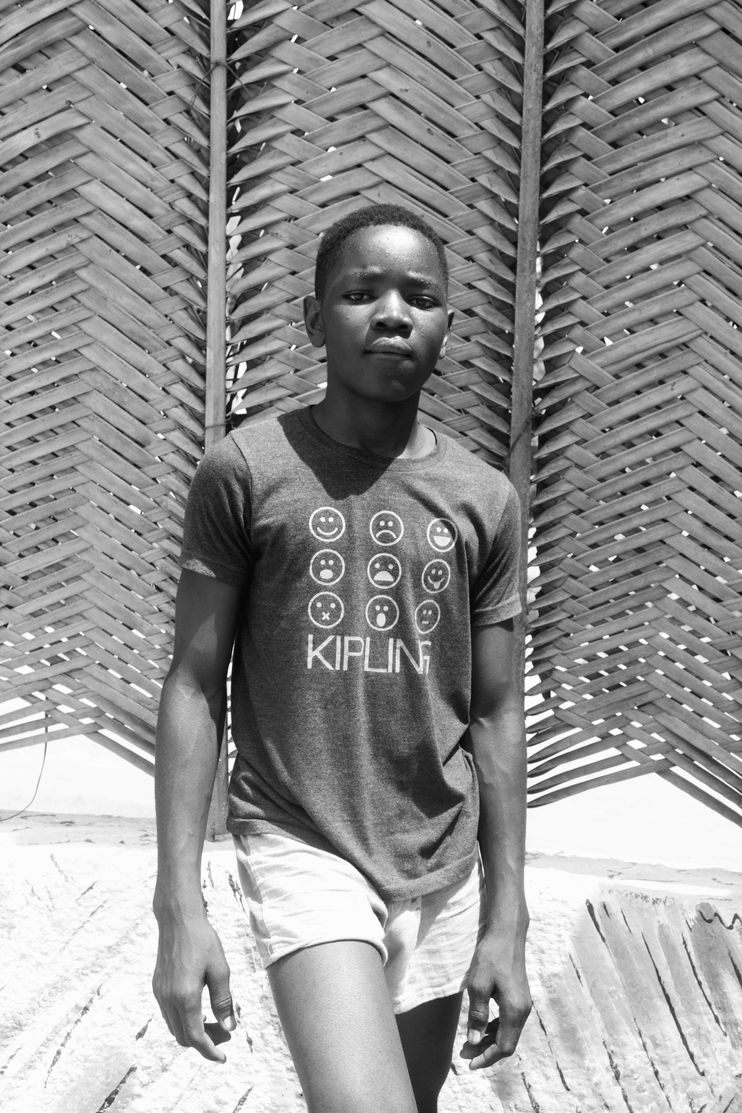 An image of a young boy standing, looking at the camera