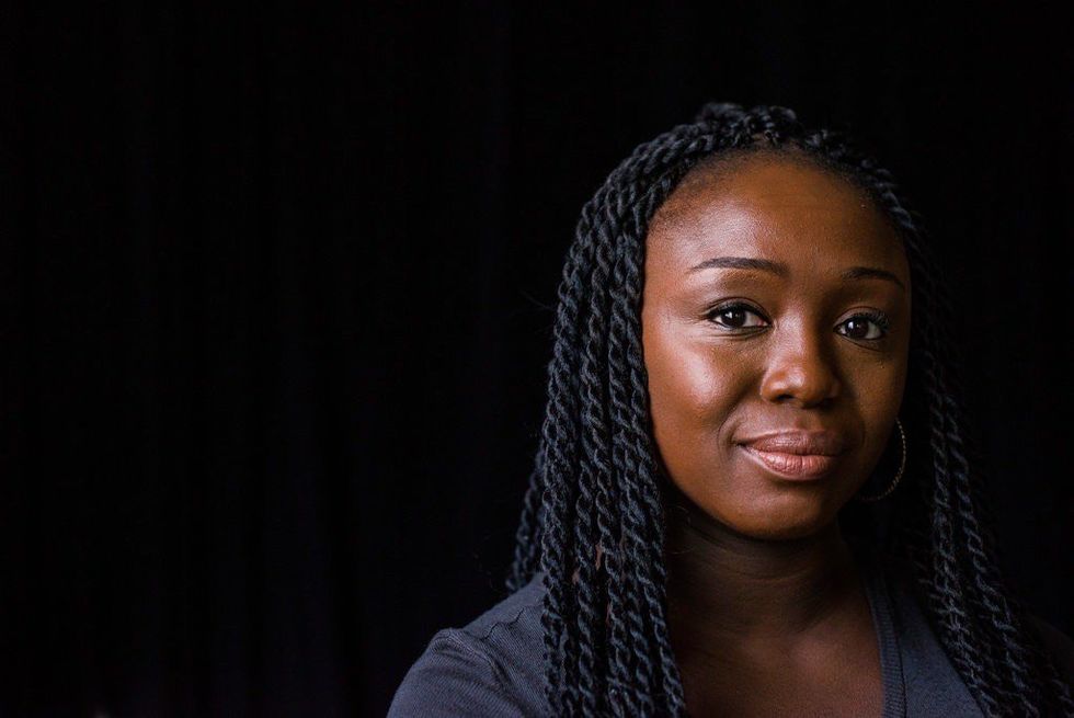 An image of the playwright, who\u2019s looking straight towards the camera, and has braids.