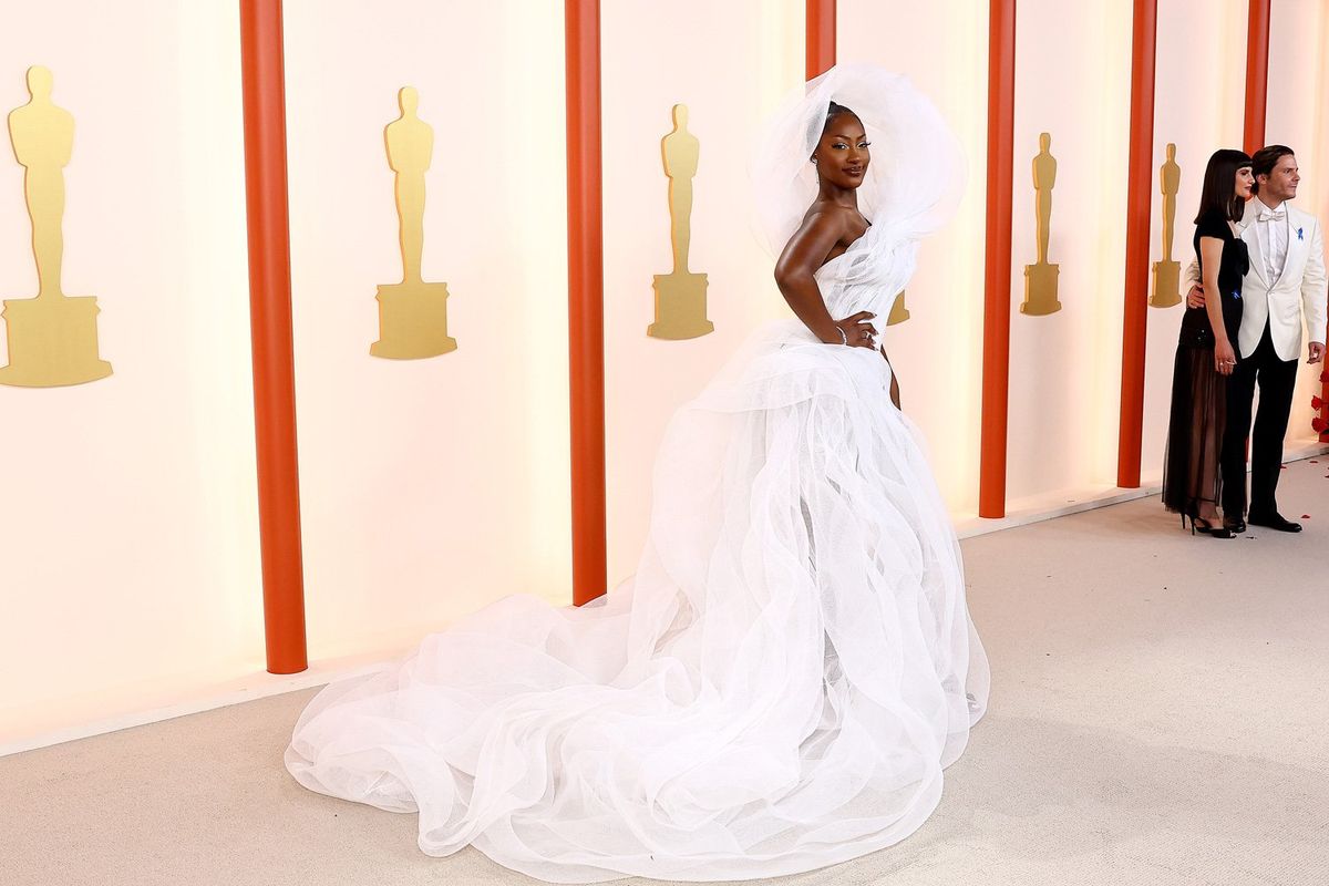 An image of the singer Tems on the Academy Awards’ red carpet wearing a spectacular white ensemble that goes over her head.