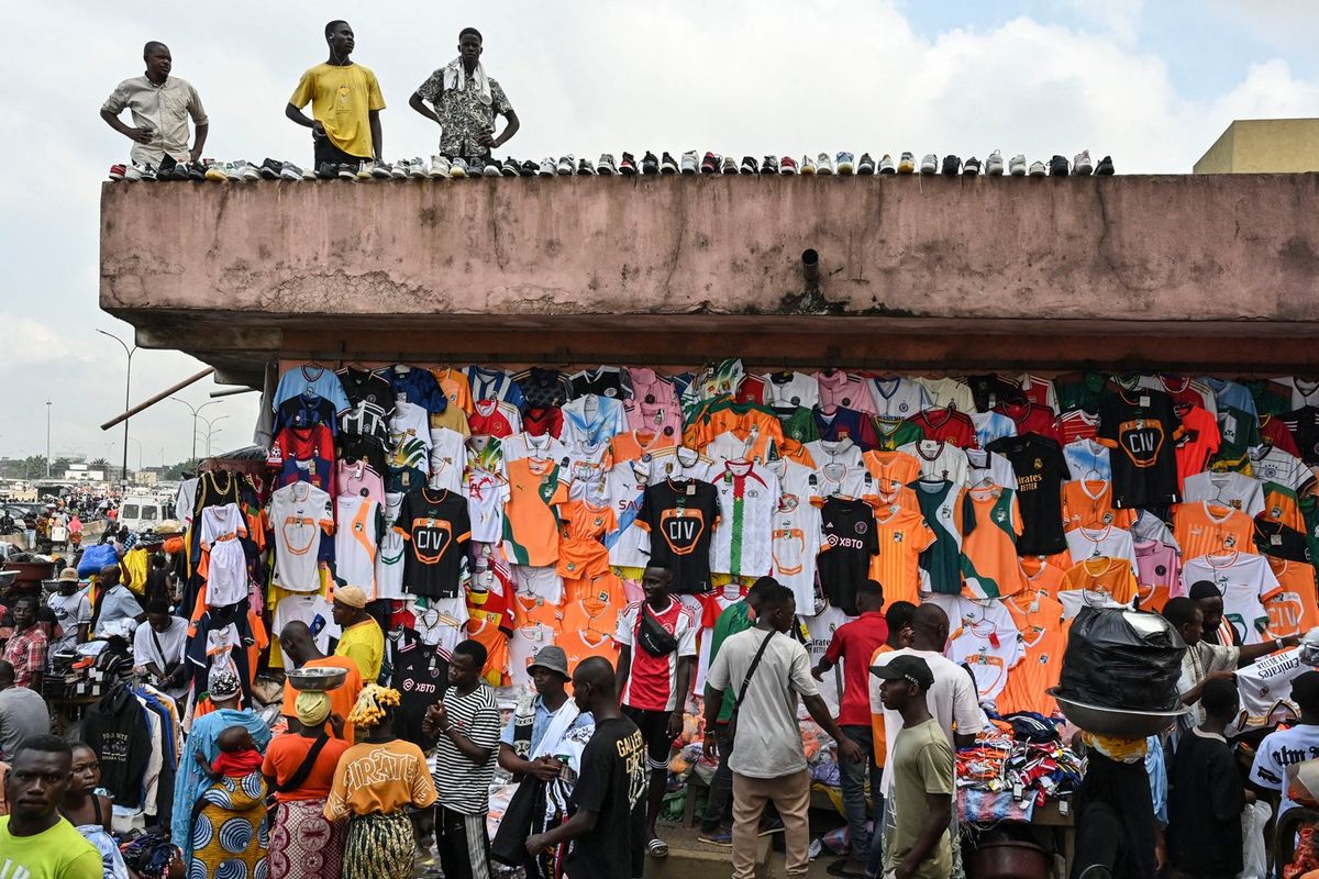 An image of vendors selling football kits at a market stall in Abidjan ahead of the 2024 Africa Cup of Nations.