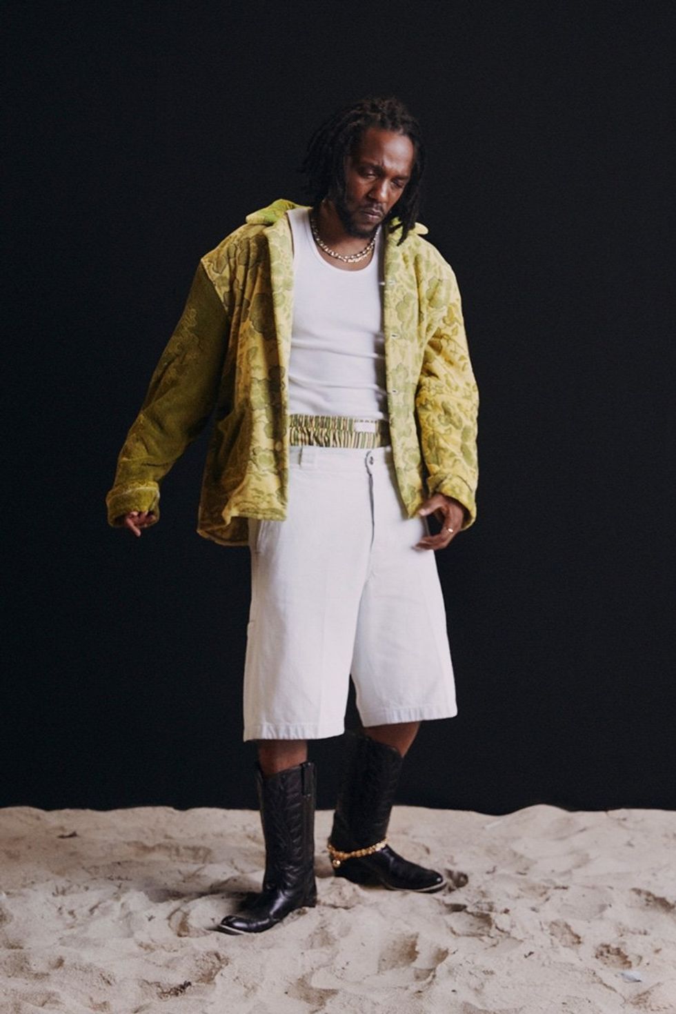 An image taken by the photographer of the rapper Kendrick Lamar in which he\u2019s wearing cowboy boots and standing on sand.