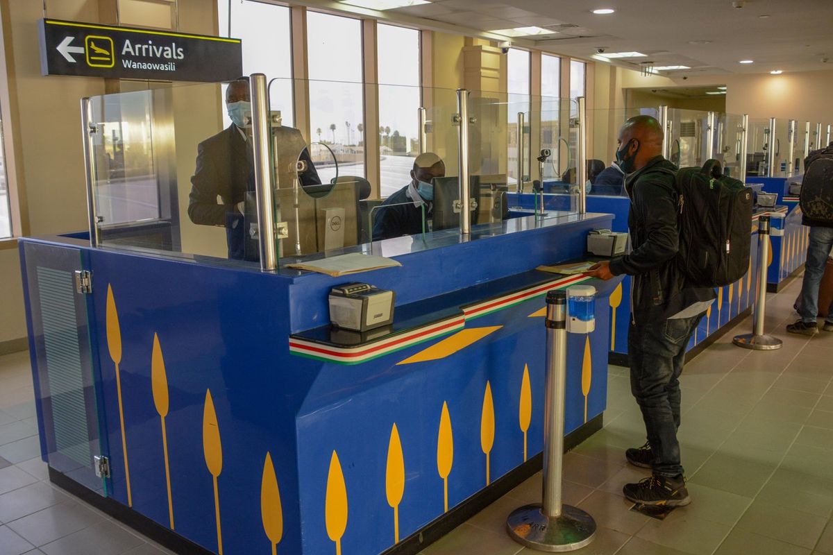 An immigration official at Jomo Kenyatta International Airport in Nairobi clears a passenger who had arrived into the country from Kigali, Rwanda on August 1, 2020.