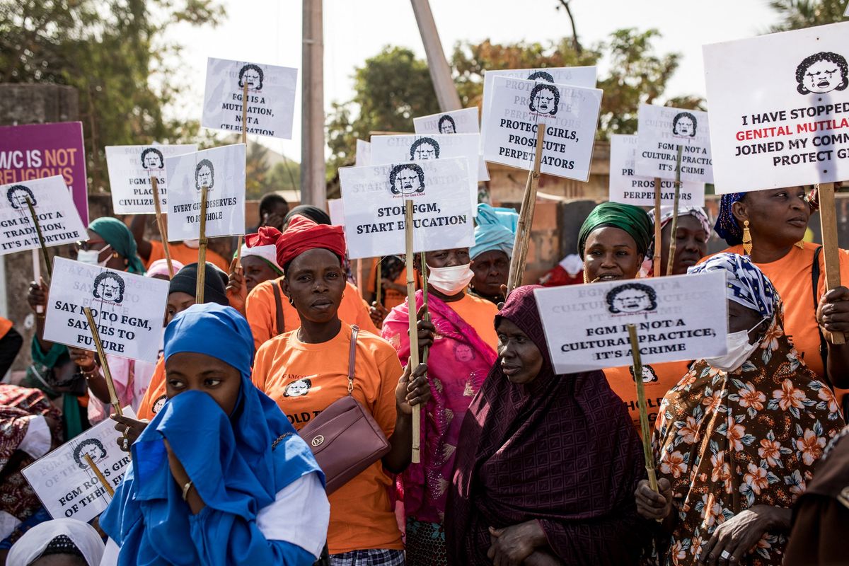 Anti Female Genital Mutilation (FGM) protesters hold placards outside the National Assembly in Banjul on march 18, 2024, during the debate between lawmakers on a highly controversial bill seeking to lift the ban on FGM.