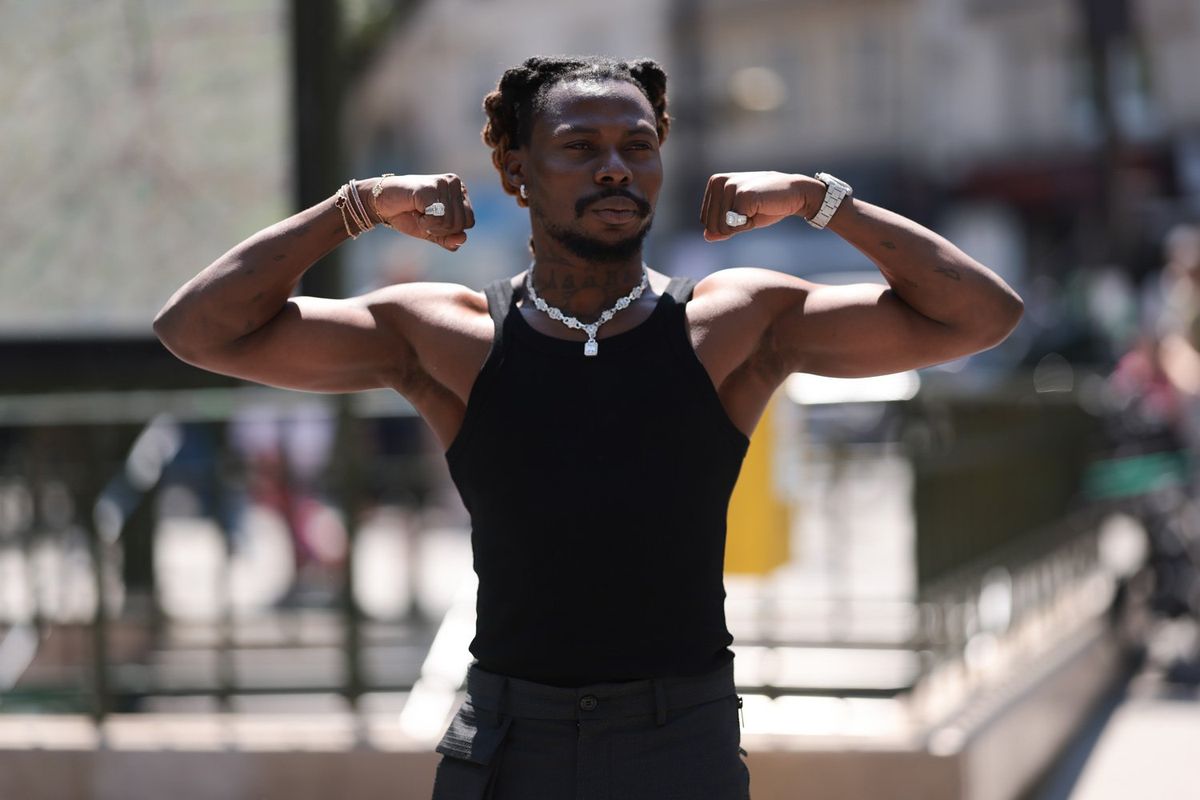 Asake is seen wearing a black tank top with diamond jewelry and a fitting dark grey trousers outside during the Sacai Menswear Spring/Summer 2024 as part of Paris Fashion Week on June 25, 2023 in Paris, France. 