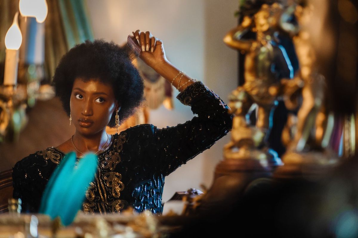 Bella Alubo sports an afro, holding a comb over her hair
