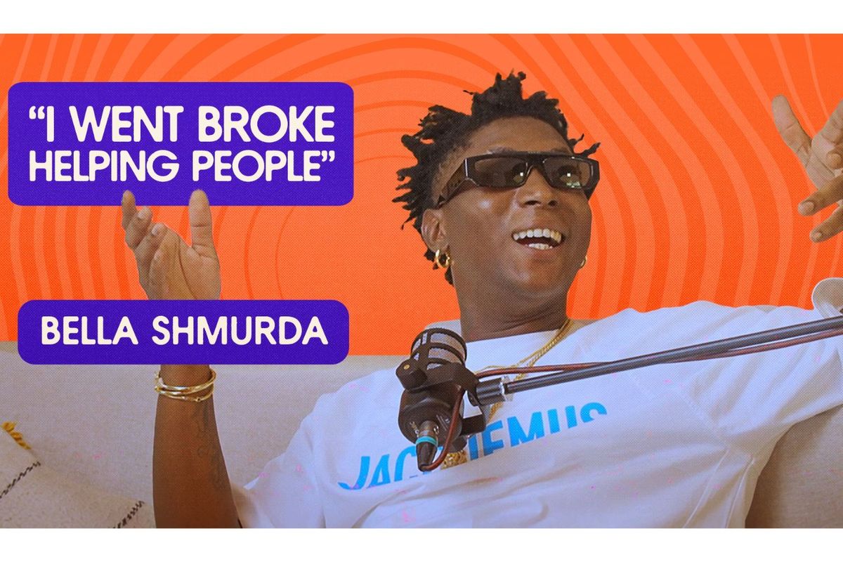Bella Shmurda smells and gestures with his hands as he talks, sittings on a couch in front of a microphone