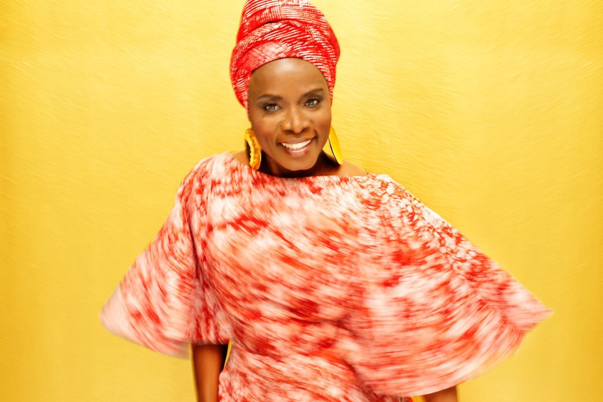 Beninese icon Angelique Kidjo poses in a red outfit. 