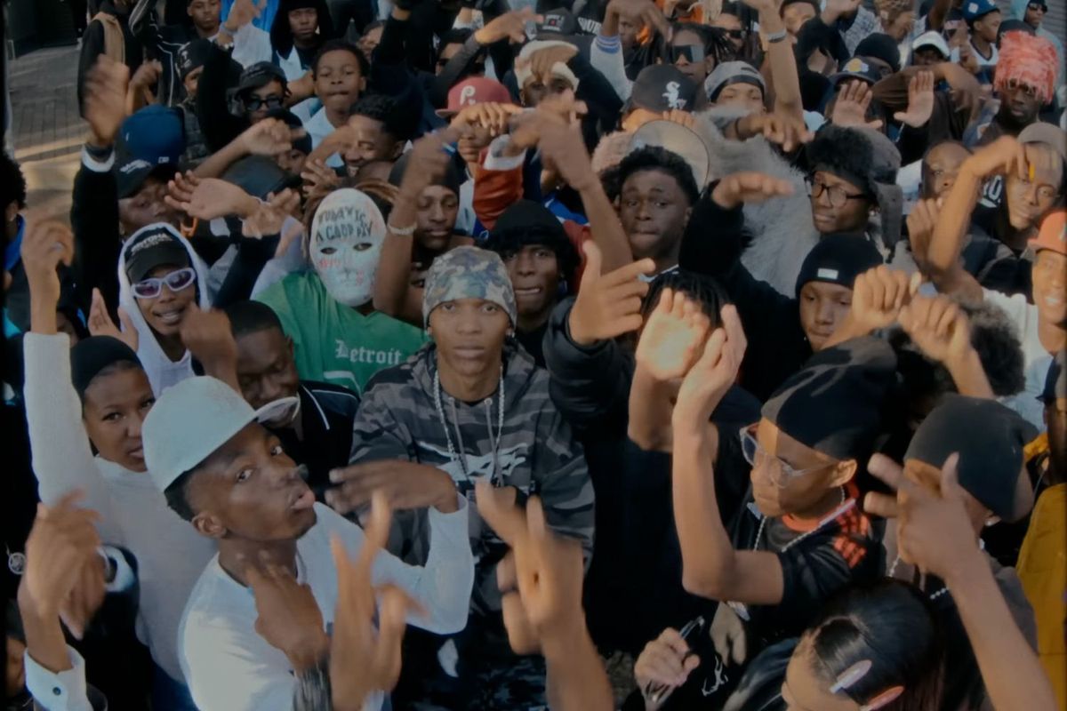 Brotherkupa is surrounded by people in the music video for “Today Is A Good Day”