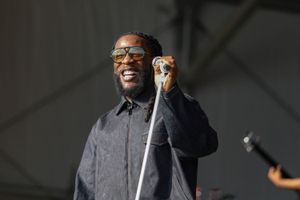 Burna Boy on stage, holding a mic and smiling