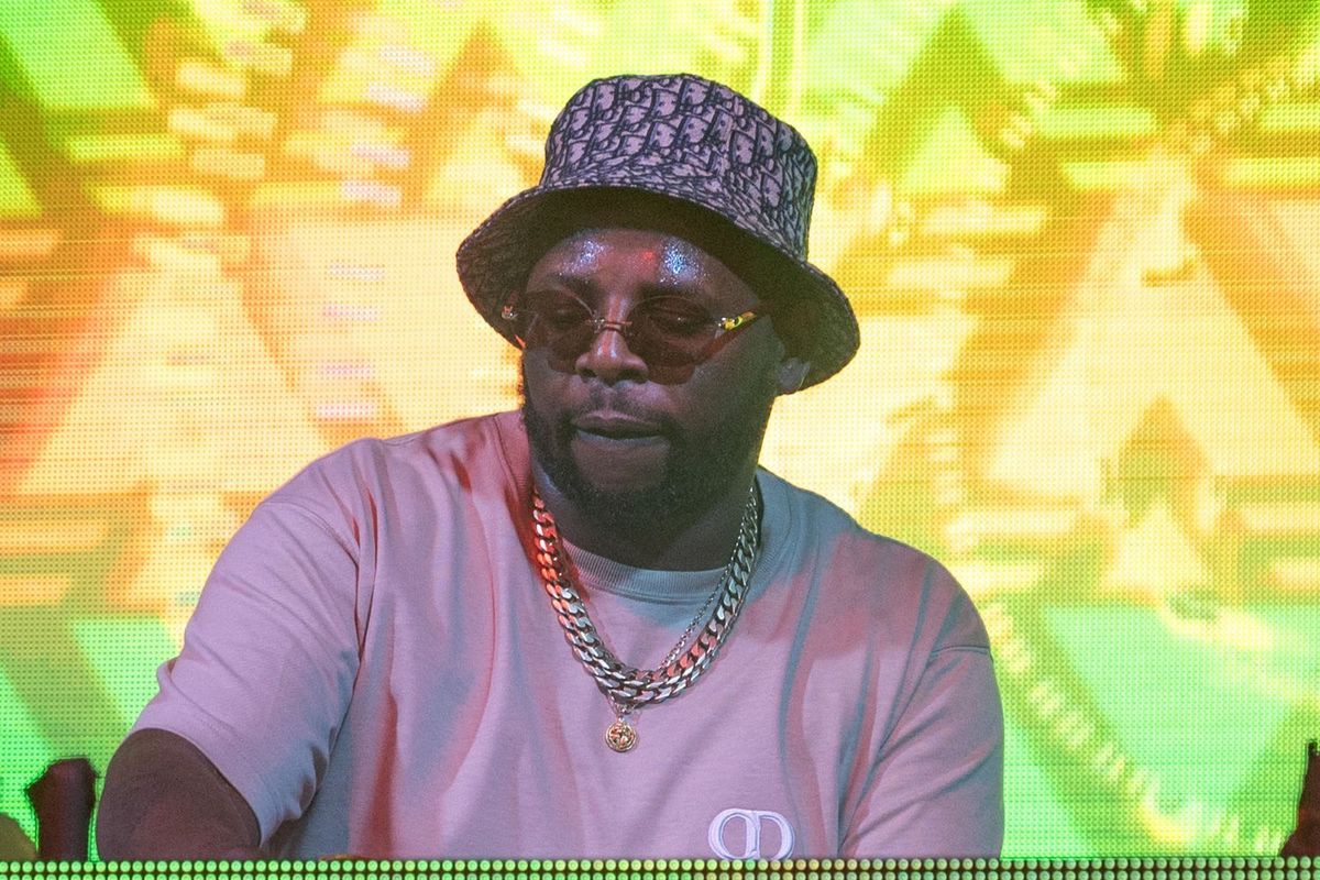 DJ Maphorisa performs on stage during Afro Nation Detroit in 2023. He wears a Christian Dior oblique reversible bucket hat, Cartier shades, and a Valentine pink Christian Dior t-shirt.