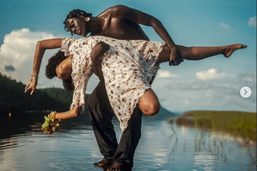 Eddie Love poses in a body of water with another dancer