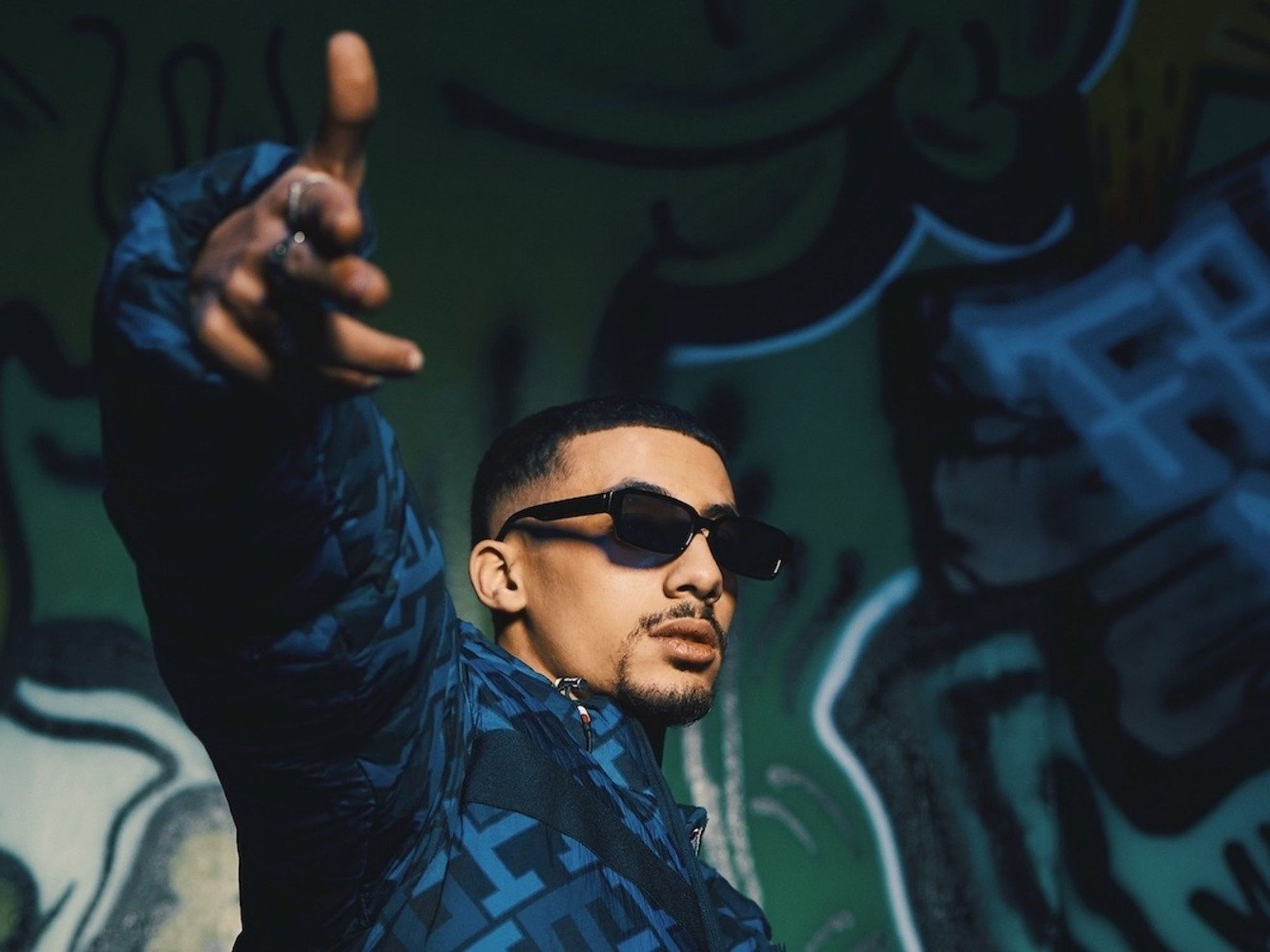 Egyptian rapper FL EX poses and points to the camera  in sunglasses