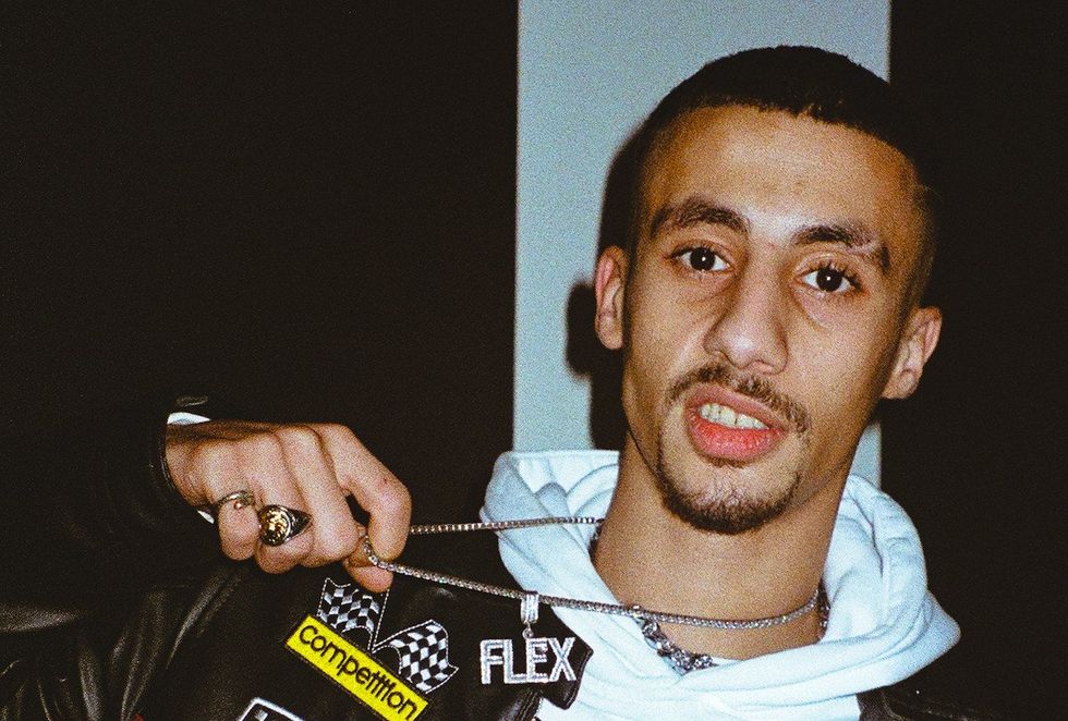 Egyptian rapper FL EX pulls on his silver chain and stares at the camera