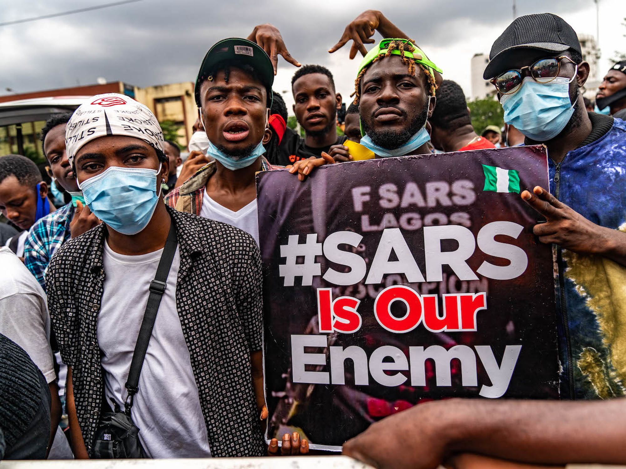​#EndSARS protestors pictured with signs reading 'SARS Is Our Enemy.'
