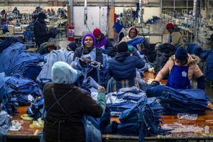 Factory workers check denim products before shipping