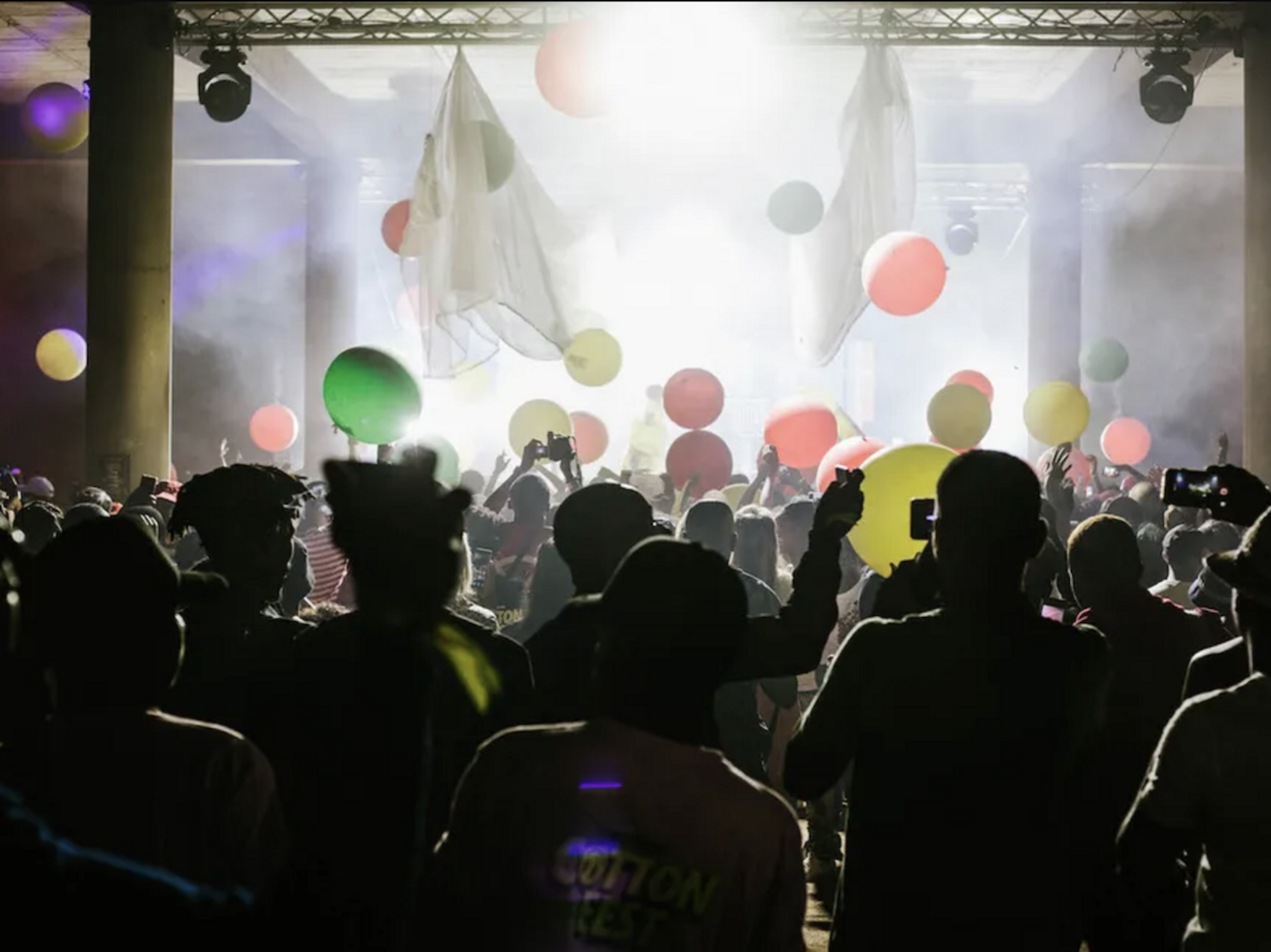 Fans in front of a stage with balloons floating at Cotton Fest 2020. 