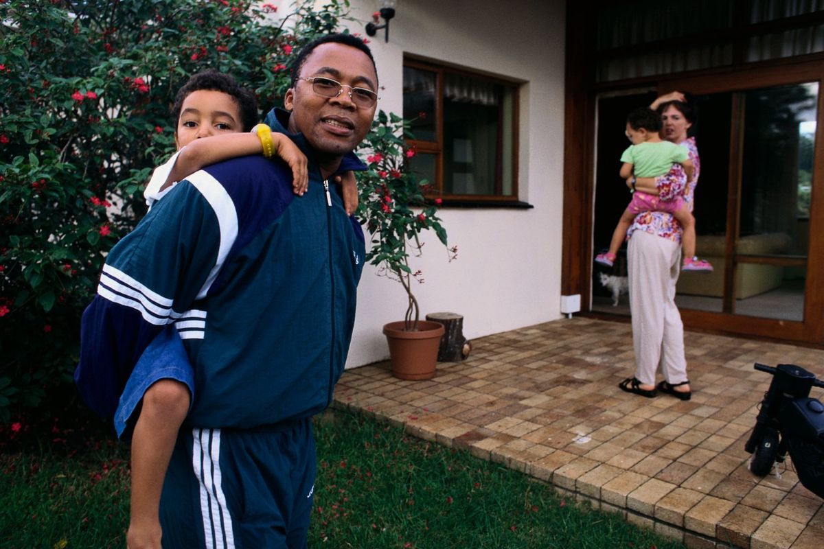 Former United Democratic Front activist Mkhuseli Jack stands with is wife and children in his family's backyard in South Africa. 