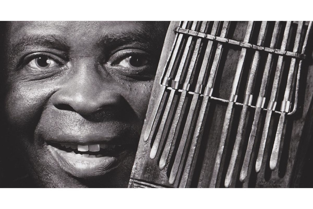 Francis Bebey poses with a mbira instrument