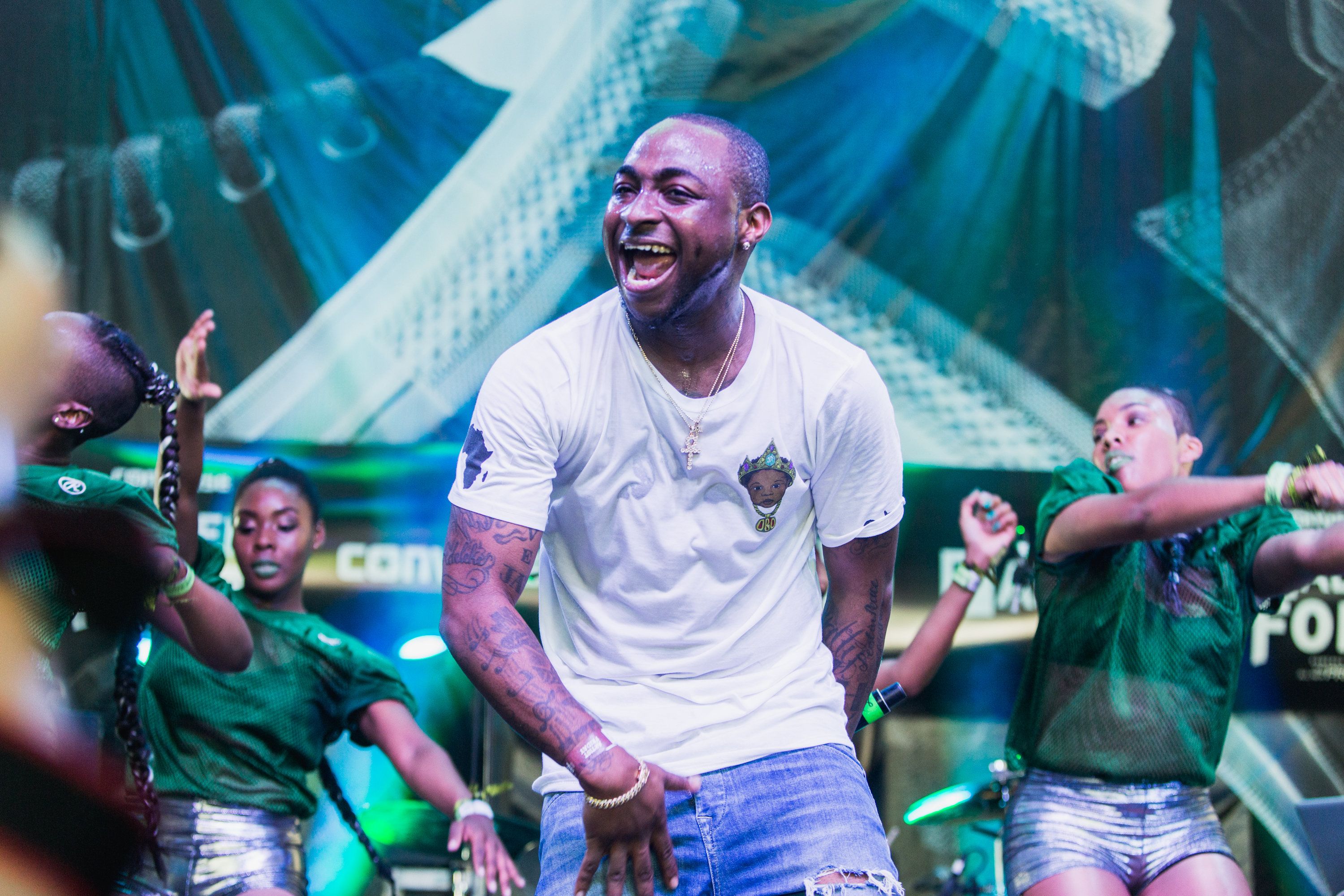 Nigerian Afrobeats Star Davido on stage in white shirt