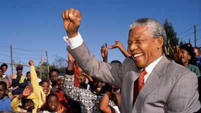 Nelson Mandela free from prison visiting a school doing the black power salute.