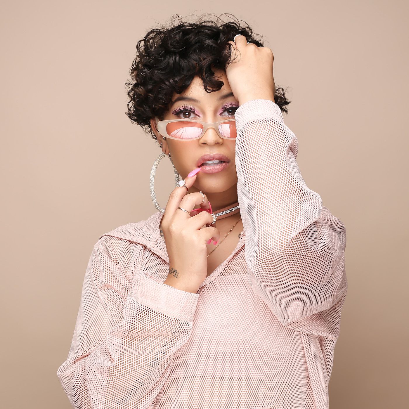 A portrait of Rowlene to a calamine-pink backdrop. 