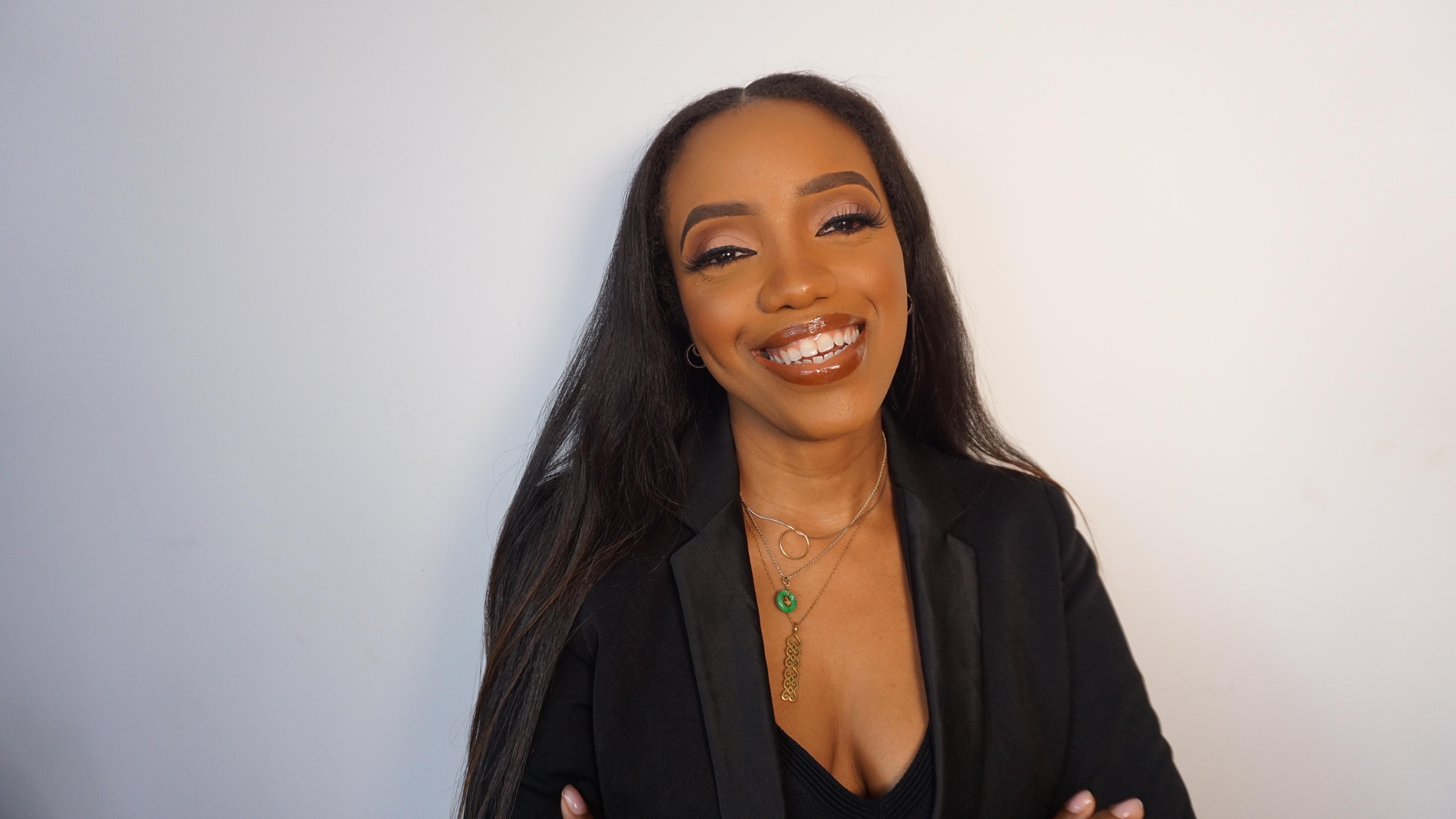 A woman wearing jewelry around her neck smiles 