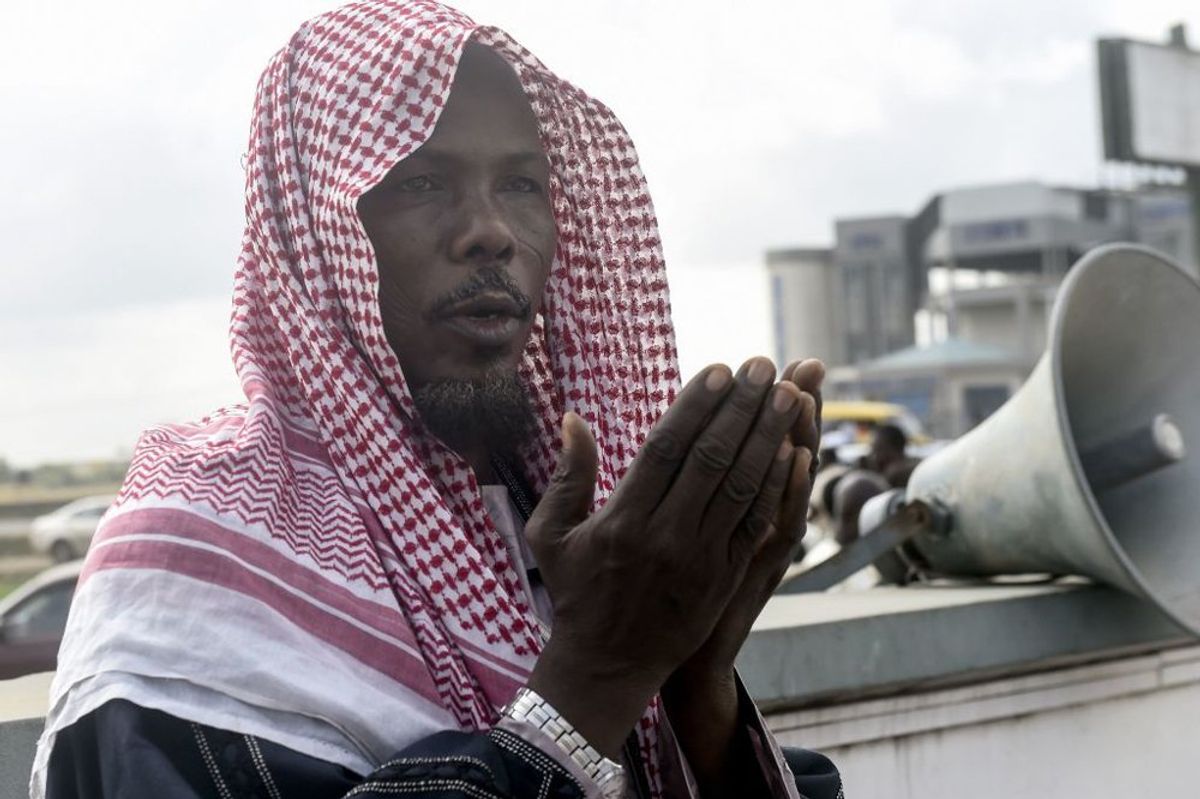 Imam Usman Kald leads the Kara Muslim community during the Eid Al-Adha (Feast of Sacrifice) prayers at Kara Isheri in Ogun State, southwest Nigeria on August 11, 2019. - Muslims across the world are celebrating the annual festival of Eid al-Adha, or the Festival of Sacrifice, which follows the annual pilgrimage to Mecca. It commemorates the willingness of biblical patriarch Abraham to sacrifice his son Ishmael and during the period Muslims distribute food to the poor.