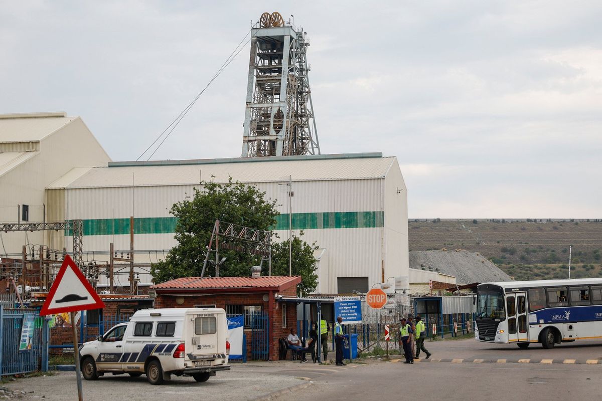 Impala Platinum mine security stand at the entrance to shaft 11 near Rustenburg on November 28, 2023. Eleven miners died and another 75 were injured in South Africa after an elevator carrying workers back up to the surface, malfunctioned and fell, the mine's operator said