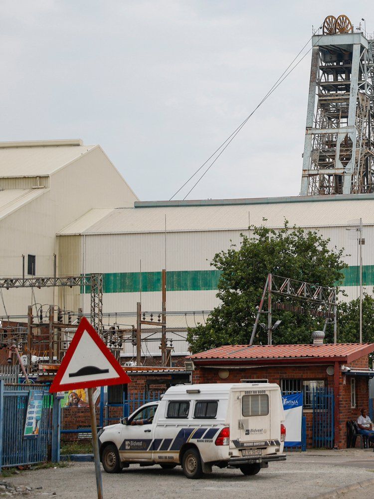 Impala Platinum mine security stand at the entrance to shaft 11 near Rustenburg on November 28, 2023. Eleven miners died and another 75 were injured in South Africa after an elevator carrying workers back up to the surface, malfunctioned and fell, the mine's operator said