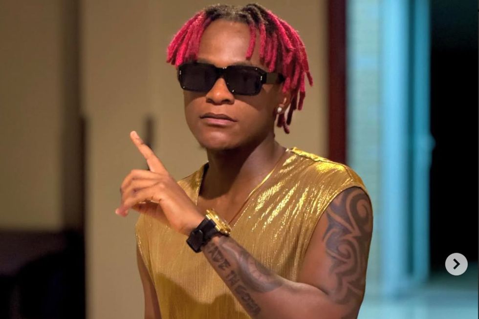 Innosu2019B spots red locks, wears shades, and has one finger raised.