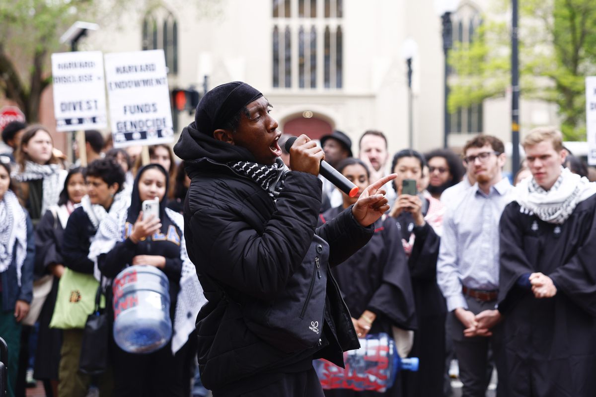 Kojo Acheampong, co-founder of the African and African American Resistance Organization, holds a mic to his mouth during a rally outside of Johnston Gate.