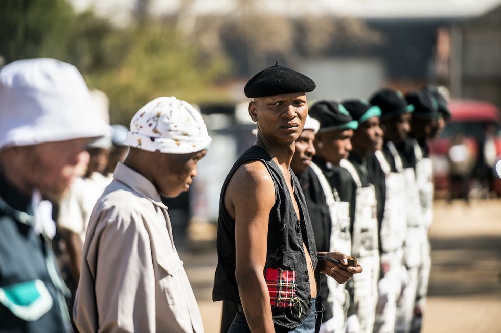 Lead actor Warren Masemola standing posing with a group of dancers on the set of Tjovitjo.