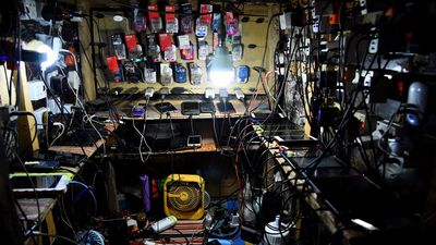 A general view of a shop with dozens of phones of clients without electricity being charged with multiple chargers at night at Ojodu district of Lagos on March 22, 2022.