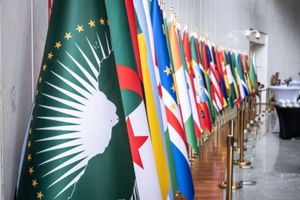 A display of African national flags alongside the African Union flag (foreground, green with a white map of Africa and gold stars), likely at a diplomatic or international event celebrating African unity or cooperation.