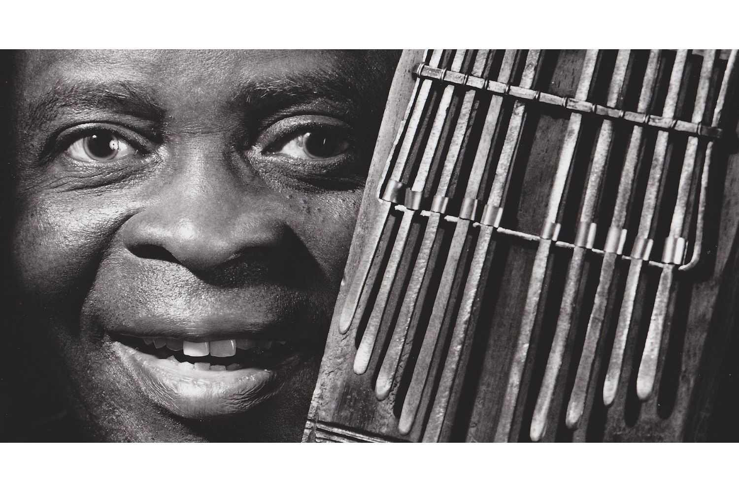 Francis Bebey poses with a mbira instrument