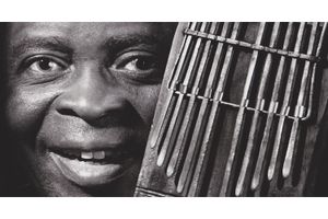 Francis Bebey poses with a mbira instrument