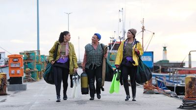 An image from the film of three women walking with various equipment in their hands.