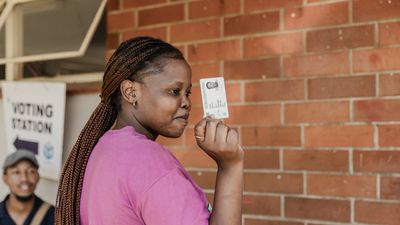​A young woman holds her identity card after she registered as a voter for the first time, ahead of the 2024 South African general elections, in the Verulam township, near Durban, on February 03, 2024.