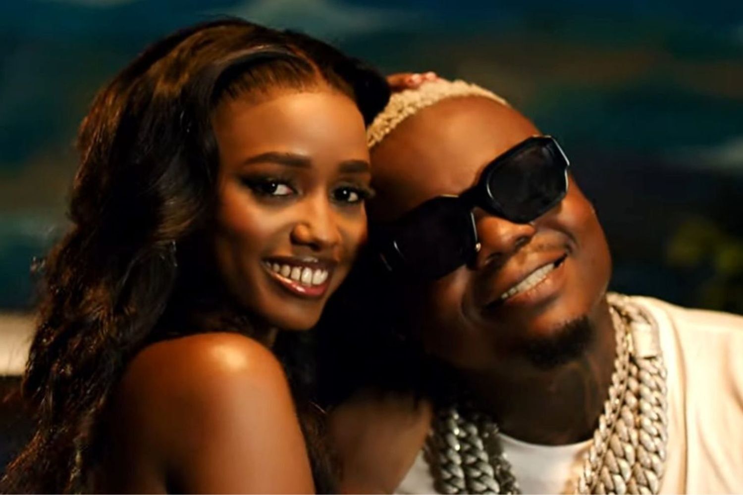 Abigail Chams smiling alongside Harmonize, both posing in a scene from the "Me Too" music video.