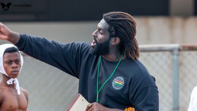 A photo of Asante Sefa-Boakye, a Black man with tied-back dreadlocks and a healthy beard, during water polo training.
