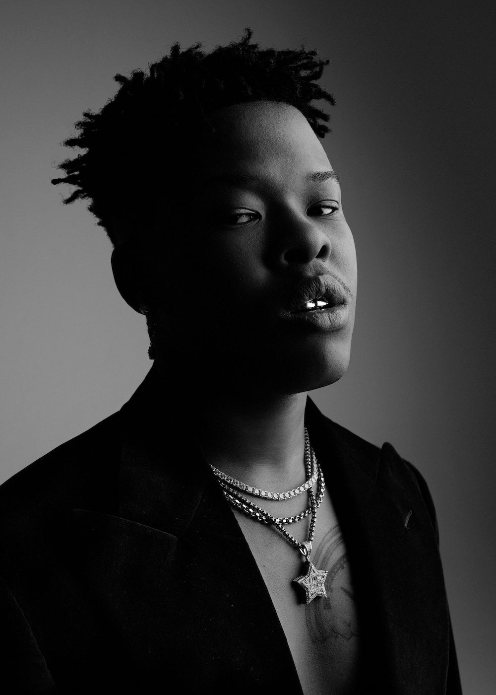 A black and white portrait of Nasty C. 