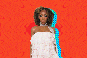 Portrait of Jackie Aina with curly hair wearing a white ruffled dress posing against a bold red-patterned background.
