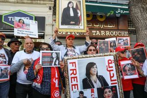 Demonstrators hold up posters of Abir Moussi