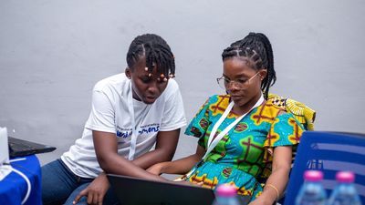 An image of two people sitting down looking at a laptop. For its first event in Ghana, Afrocuration partnered with nonprofit independent internet radio station, Oroko Radio, and the Twi User Language Group. 
