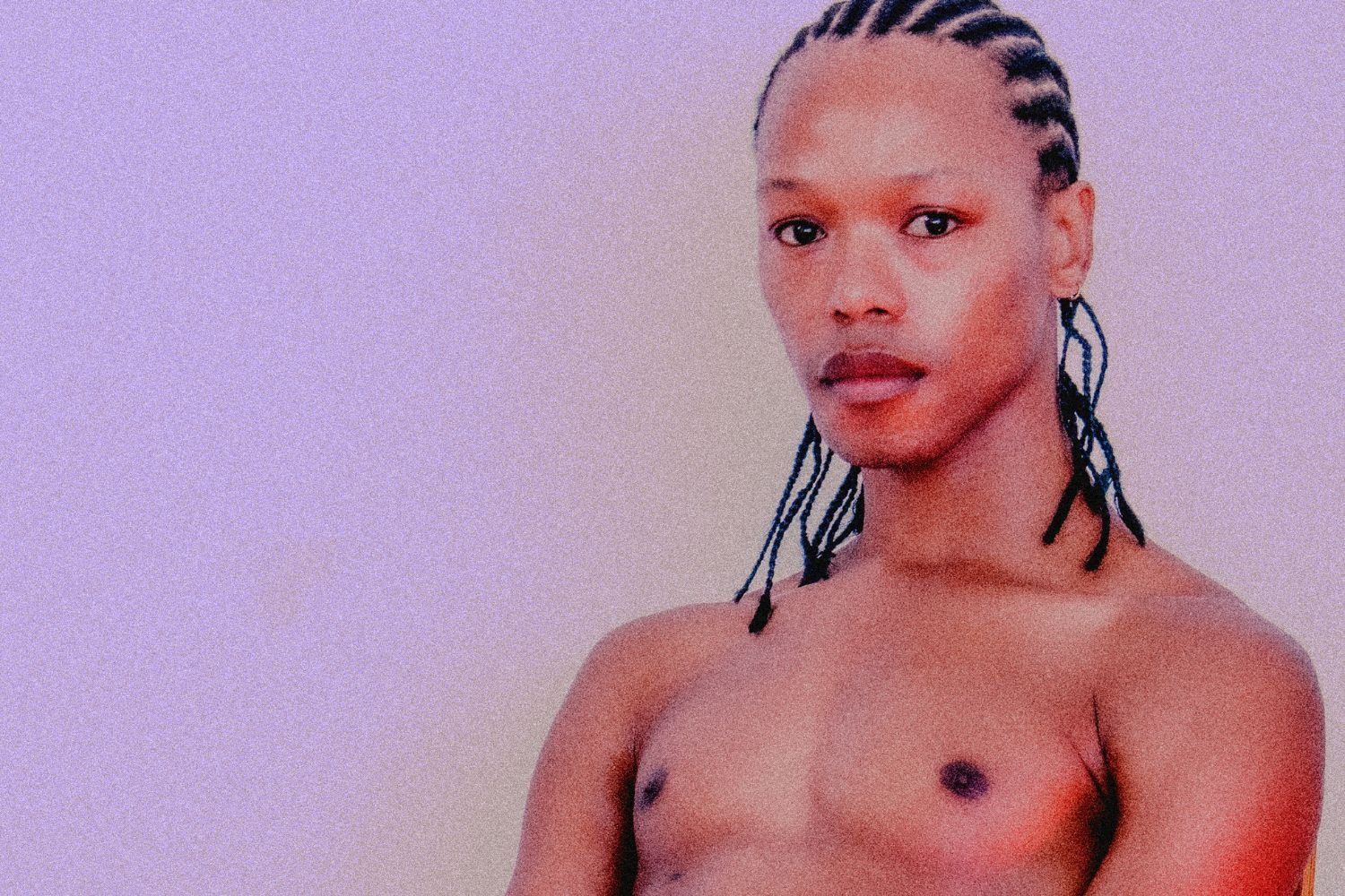 South African artist Nakhane poses shirtless, stares at the camera. 