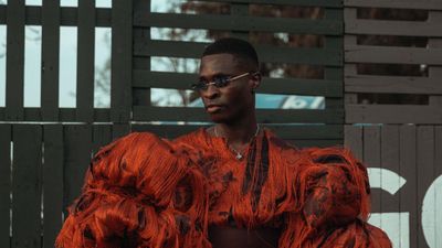 Model wearing orange coat Lagos Fashion Week 2021