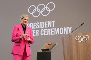 Kirsty Coventry, in a pink suit and black shirt, holds the Olympic key during the IOC presidential handover ceremony at Olympic House on June 23, 2025 in Lausanne, Switzerland.