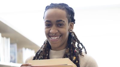Queer woman holding books