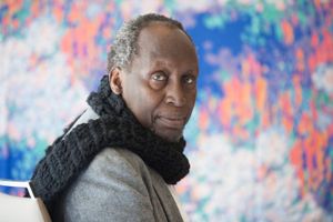 Late Kenyan literary giant Ngũgĩ sits on a chair and looks directly at the camera