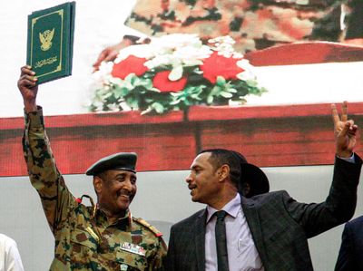 Sudan military man dressed in army uniform waves peace deal 